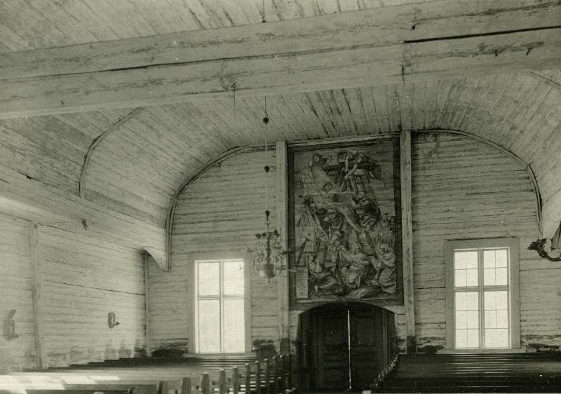Esikatselukuva: Kempeleen kirkko
	
		Kuva kirkkosalista ulko-ovelle, jonka yläpuolella seinämaalaus.