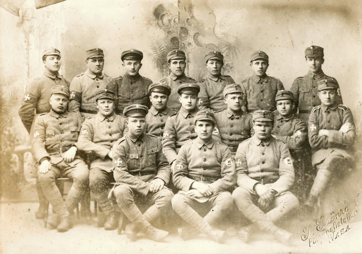 ???resource.thumbnail???: Gruppfotografi av unga militärklädda män.
	
		Gruppfotografi av unga militärklädda män. Alla bär bindel runt högra överarmen med FInlands flygv...