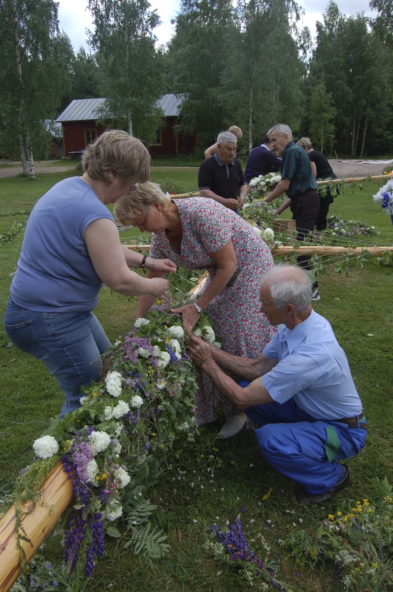 Thumbnail: Blommor fästs vid stången.