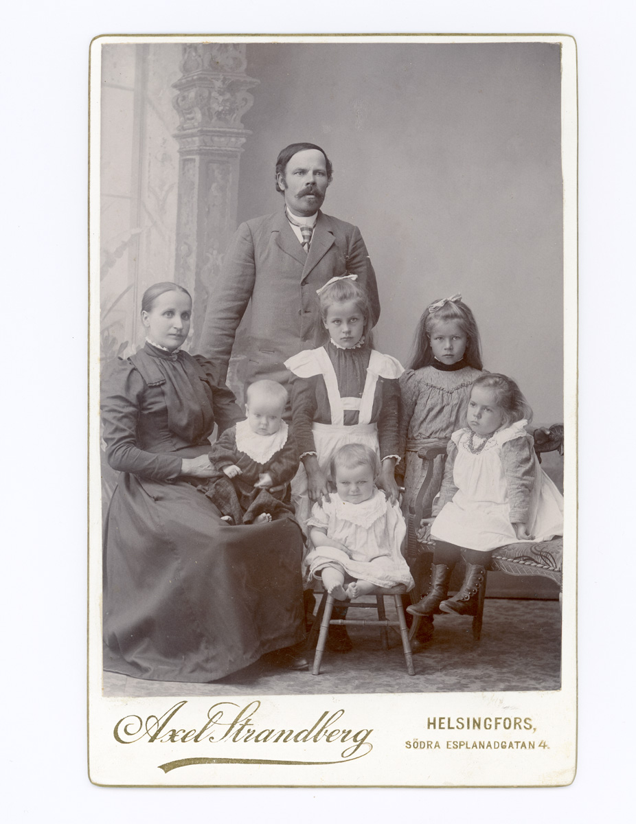 ???resource.thumbnail???: Gruppbild av familj; far, mor, fem barn.
	
		Gruppbild av familj; far, mor, fem barn. Text: "Ville Kuorikoski m. familj. Blev bonde i Kar...
